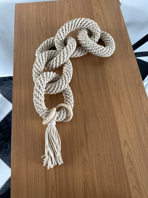 Peça em elos de crochê recém-montada sobre a mesa de trabalho do ateliê.
